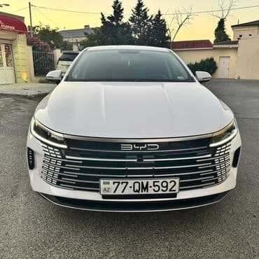 BYD sedan – ağ rəng, aerodinamik kuzov və geniş xrom ön barmaqlıq. Ön