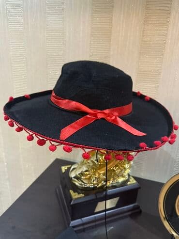 Qara rəngdə geniş kənarlı şlyapa. Qırmızı lent və qırmızı pomponlarla