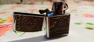 forma herbi: Metall korpuslu, benzinli (şamlı/fitilli) qapaxlı alışqan. Ön paneldə — 5