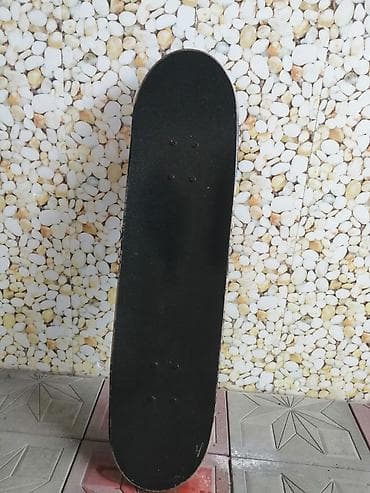 forması: Skateboard – qara rəngli gövdə, üzərində ağ kəllə‑sümük naxışları. - — 3