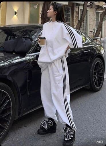 Ağ rəngli, boş kəsimli qadın idman kostyumu. Bu idman kostyumu