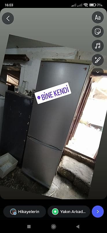 Gümüşü rəngdə, iki qapılı soyuducu. Üst qapı soyuducu hissə, alt qapı — 1