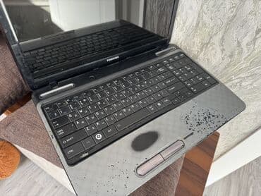 notebook çanta: Toshiba markalı boz rəngli noutbuk. Cihazın üst qapağında Toshiba — 4