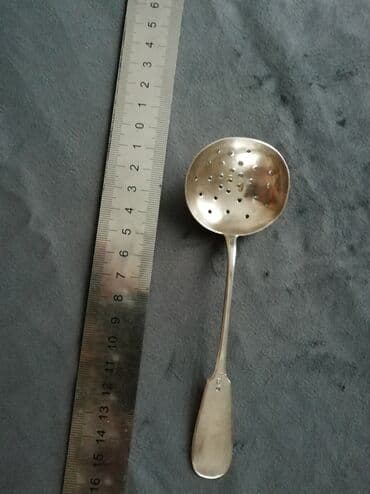 Gümüş, dəyirmi formalı, deşikləri olan bir süzgəc qaşıq. Uzun, incə