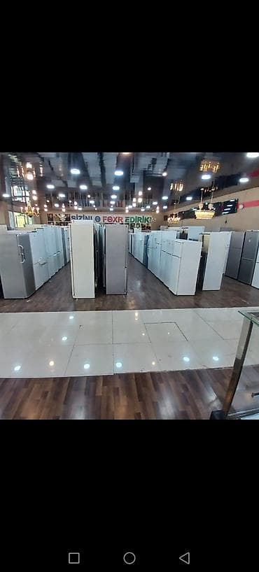 Məişət texnikası mağazasında müxtəlif model soyuducuların geniş