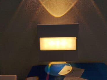 Düzbucaqlı formalı, ağ rəngli divar lampası. Otağa mülayim işıq saçır