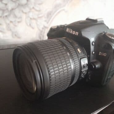 notbuk ucuz: Nikon D90 rəqəmsal güzgülü kamera. Kameranın qara rəngli korpusu var — 3