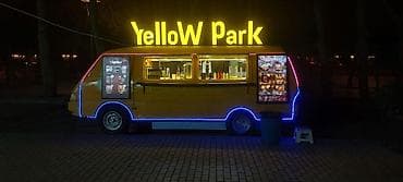 Sarı rəngli, işıqlı “Yellow Park” fast-food furqonu. - Menyu