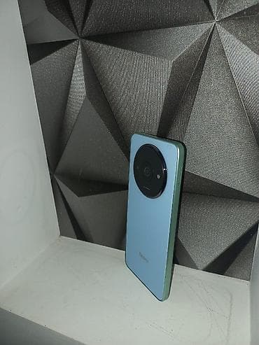 telefonlae: Redmi smartfon. Cihaz açıq mavi rəngdədir və arxa hissəsində böyük — 2
