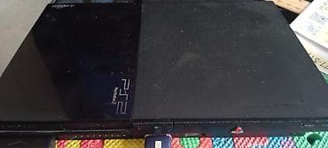 Sony PlayStation 2 konsolu. Qara rəngdə olan bu konsol, disk oxuyucuya