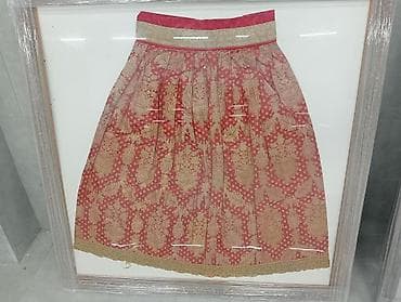 Qızılı naxışlı qırmızı ətək – çərçivədə dekorativ ekspozisiya.Qedimi