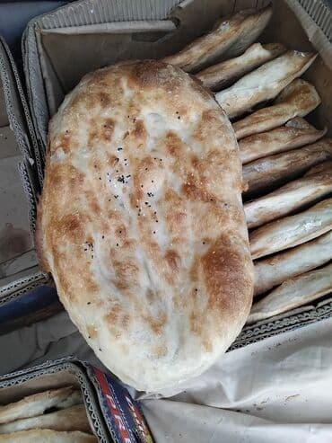 Un məmulatları: Oval formalı təzə bişmiş çörək. Üzərində qızılı qabıq və qara zirə — 2