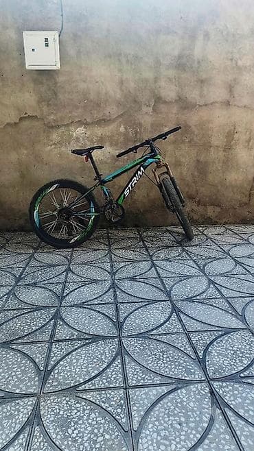 STRIM markalı dağ velosipedi, qara rəngdə, yaşıl və mavi detallarla