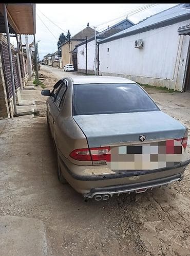 saipa 132 se: Açıq qəhvəyi rəngdə sedan tipli avtomobil. Avtomobilin ön hissəsində — 2