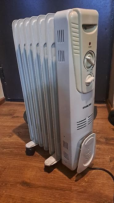 NIKAI markalı, təkərlər üzərində dayanan yağlı radiator. Bu model evdə