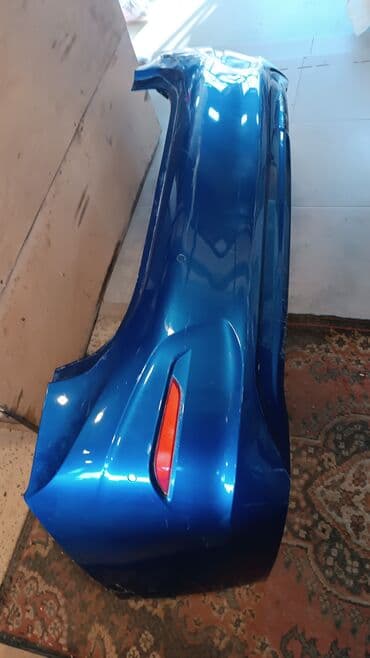 Mavi rəngdə olan avtomobilin arxa bamperi. Bamperdə qırmızı rəngli əks