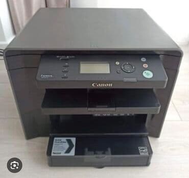 kompyuterlər: Qara rəngdə olan Canon lazer printeri. Ön tərəfində idarə paneli və — 2