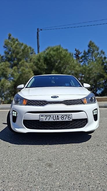 Kia: Kia Rio sedan – ağ rəng, Azərbaycan nömrə nişanı ilə. Şəhər və uzun — 1