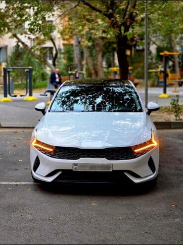 Kia K5 sedan – ağ rəng, fastback silueti və panoramik şüşə dam