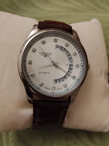 Longines üslubunda kişi qol saatı. Saat ağ rəngli siferblata malikdir