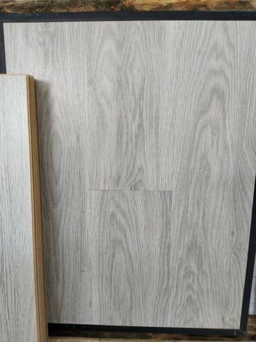 laminat pol: Açıq boz rəngdə laminat döşəmə panelləri. Taxta naxışlı səthi var — 1