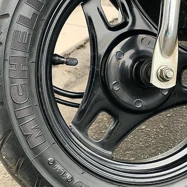 18 disk təkər: Gümüşü rəngdə, qara detallarla bəzədilmiş Suzuki skuter. Bu model — 3