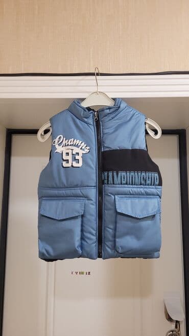 Mavi rəngdə uşaq jileti. Qabaq tərəfində "Champs 93" yazısı və yan