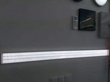 Uzunsov formalı, ağ işıq saçan LED işıq paneli. Divara quraşdırılıb və