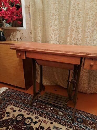 Paltar tikən maşın. Qədimdir. Ayaqla işləyir