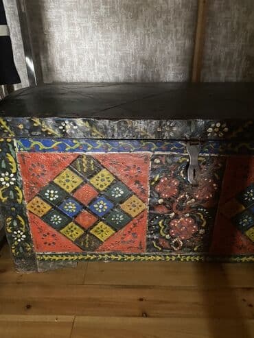 Əl işi olan, rəngli naxışlarla bəzədilmiş taxta sandıq. Qapağı qara