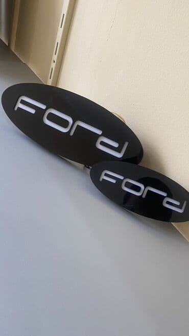 ağ qapilar: Ford loqosu ilə işıqlı nişan, qara fonda ağ rəngdə işıqlandırılmış — 2