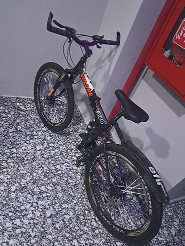 velo disk: Velone markalı qatlanan dağ velosipedi. Velosiped qara rəngdədir və — 2
