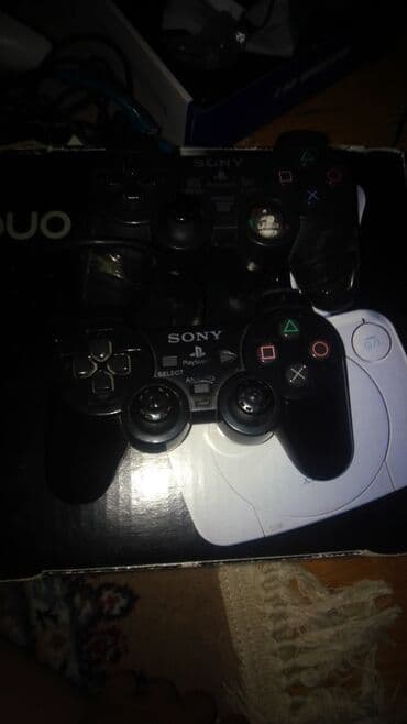 ps2 diskləri: Sony PlayStation One oyun konsolu. Ağ rəngdədir, yığcam dizaynı ilə — 3