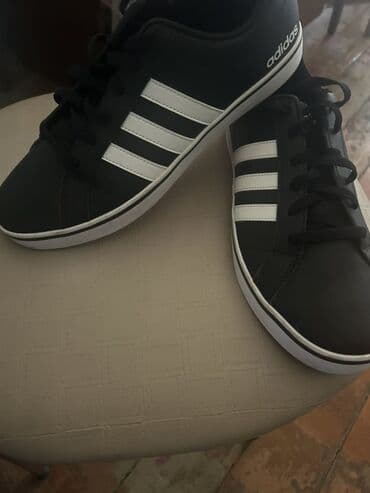 Botinkalar: Adidas brendinin qara rəngli, ağ zolaqlı kişi krossovkaları. Bu — 1