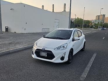 Toyota Aqua (hibrid) – ağ rəng, 5 qapılı hetçbek. Texnologiya və