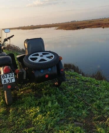 reduktor suretler qutusu: Yan qoşqulu qara motosiklet. Motosikletin ön hissəsində külək şüşəsi — 3