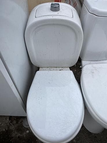 Ağ rəngli, kompakt ölçülü unitaz. Yuxarıdan mərkəzi düymə ilə mexaniki