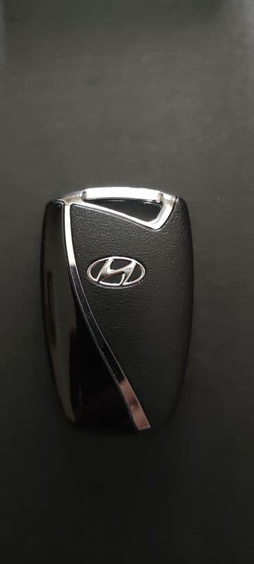 Hyundai avtomobilinin qara rəngdə olan açarı. Açarın üzərində metal
