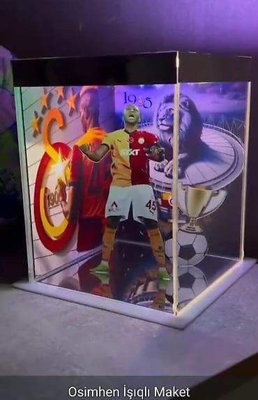 Şəffaf akril qutuda, daxili işıqlandırması olan futbolçu Osimehnin