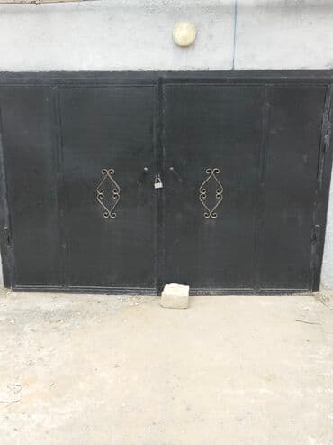 Metal qaraj qapısı. Qalın metaldan hazırlanmış, iki taylı konstruksiya