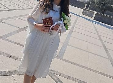 Ağ rəngli, dizdən bir az yuxarı uzunluqda plissəli paltar. - Model