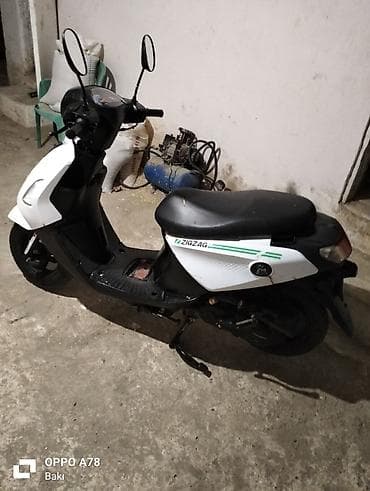 ZIGZAG skuter - Rəng: ağ/qara, yan panellərdə ZIGZAG loqosu və yaşıl