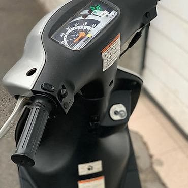 18 disk təkər: Gümüşü rəngdə, qara detallarla bəzədilmiş Suzuki skuter. Bu model — 5
