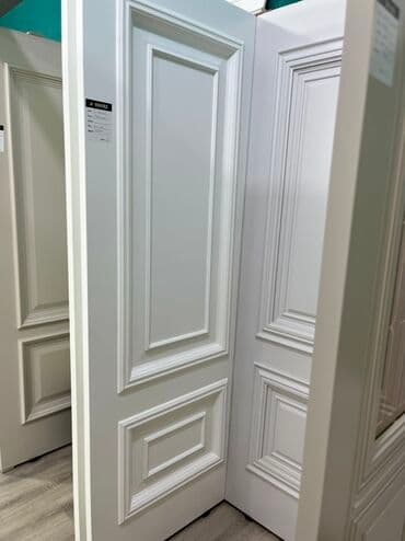 Ağ rəngdə, klassik dizaynlı qapı. Panellərlə bəzədilmişdir və ev və ya