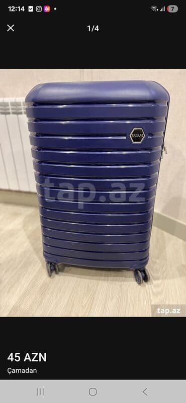 İdman qidaları: Dörd təkərli, tünd göy rəngli səyahət çamadanı. Çamadanın ön — 1