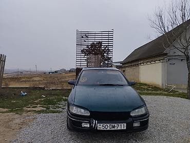 Opel: Opel sedan – yaşıl rəng, 4 qapılı, arxa çəkiliş emblemli model. Xarici — 2