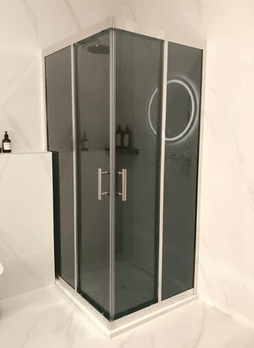 Kvadrat formalı, tünd şüşəli duş kabinəsi. Gümüşü rəngli metal