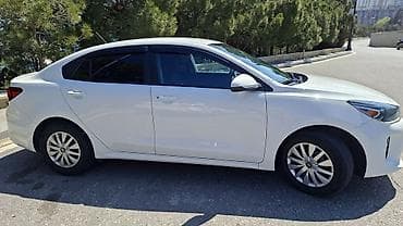 Kia: Kia Rio sedan – ağ rəng, Azərbaycan nömrə nişanı ilə. Şəhər və uzun — 4