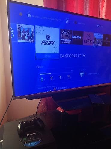 15 pro max titanium: Sony PlayStation 4 konsolu, DualShock 4 nəzarət cihazı və "FC24" oyunu — 2