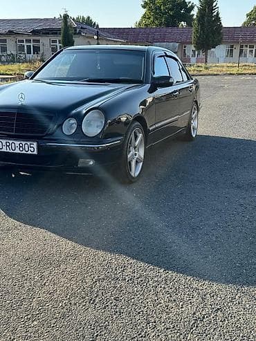 Mercedes‑Benz E‑Class (W210) sedan, qara rəng, tünd plyonka ilə